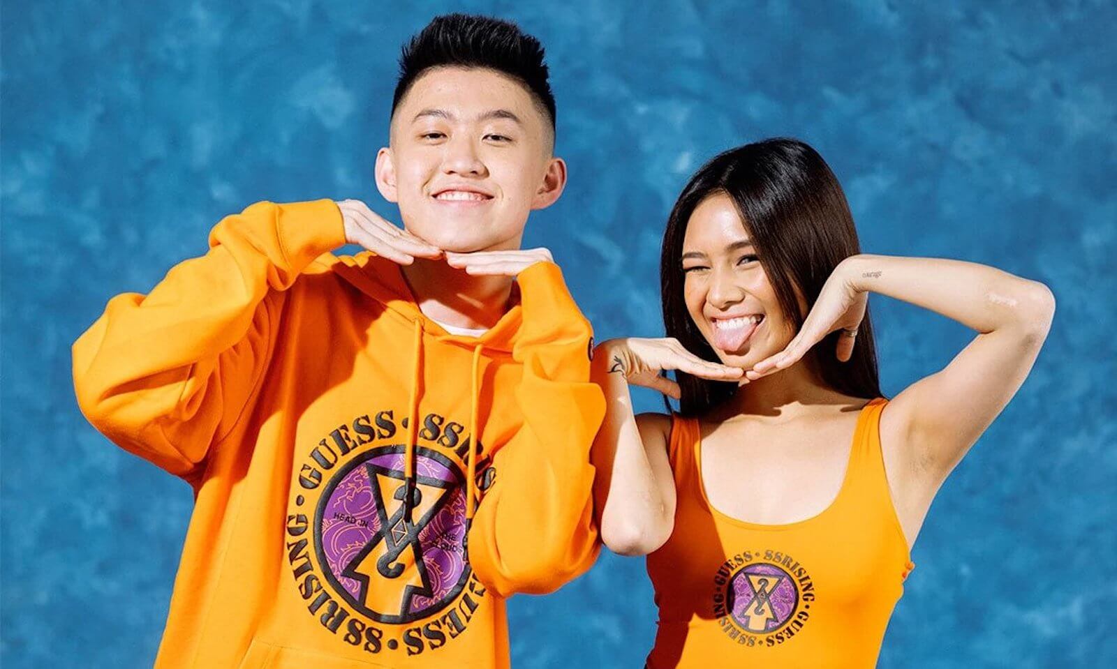 Rich Brian dan Niki menggunakan outfit dari Guess dengan warna orange